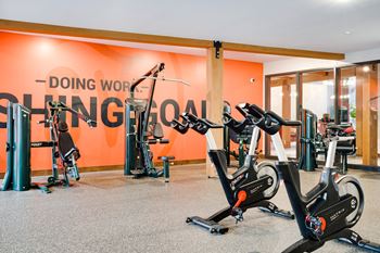 a gym with several exercise bikes and a wall with the words doing work lingo